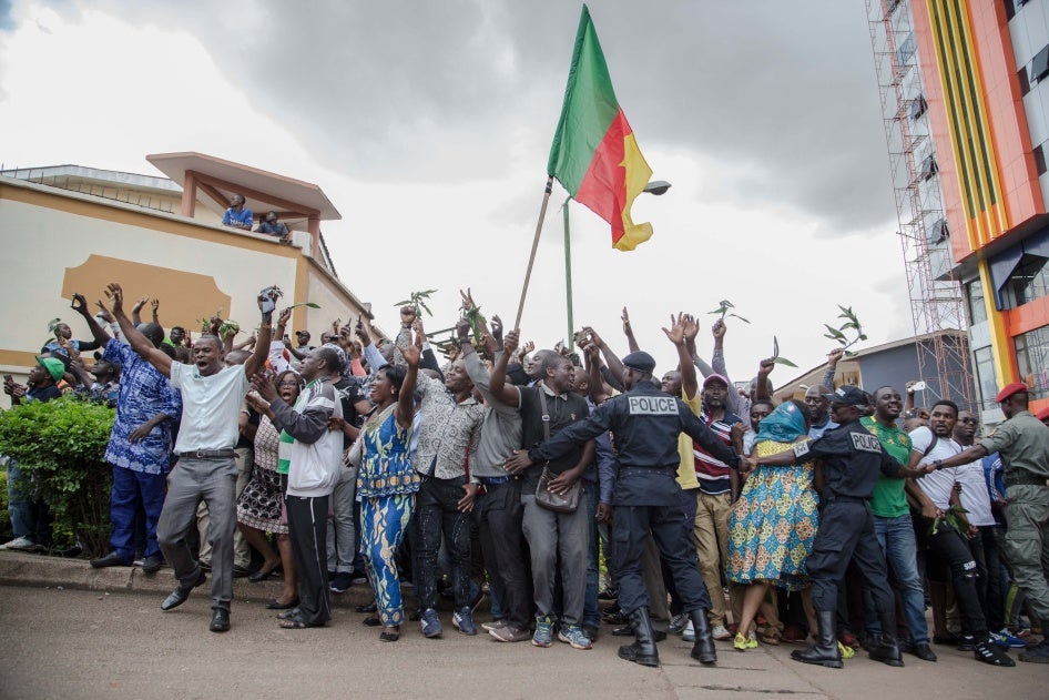 Hundreds of supporters raise their arms and wave the national flag while waiting to greet Cameroonian opposition leader Maurice Kamto in Yaoundé on October 5, 2019, the day of his release from prison.