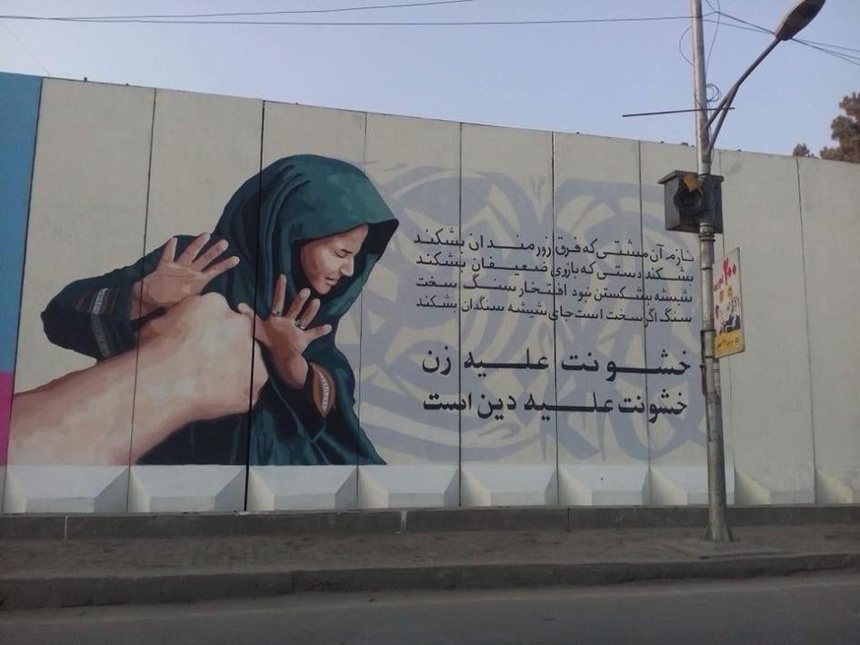 A painted mural with Arabic writing on a building 