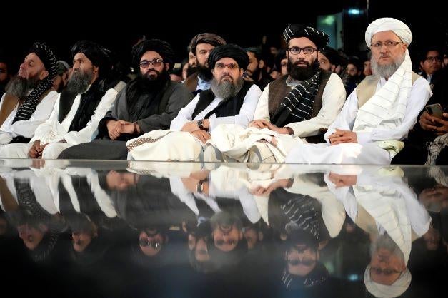 Taliban leaders sit in a row at a ceremony