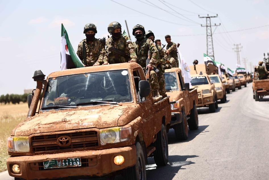 Fighters of the Turkish-backed Syrian National Army take part in a military parade in the countryside of Aleppo Governorate on June 9, 2022, as part of the forces' preparations for military actions on the areas controlled by the Syrian Democratic Forces.