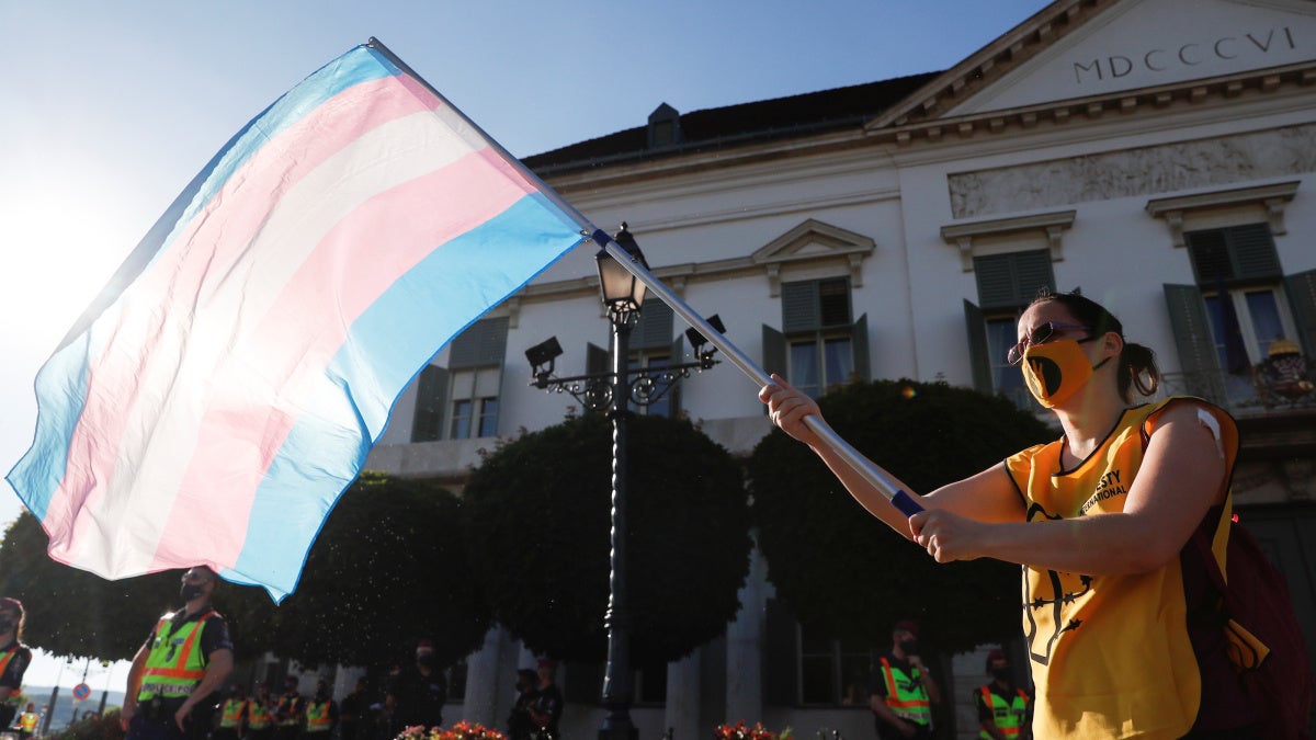An activist waves the transgender flag during a protest at the Presidential Palace in Budapest.
