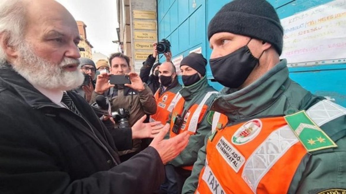 Pastor Gabor Ivanyi of the Hungarian Evangelical Fellowship speaks with National Tax and Customs officials during an armed raid on his church center in Budapest