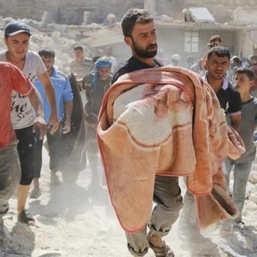 Relatives mourn as a man carries the body of a dead boy in a blanket at a site hit by what activists said was a barrel bomb dropped by forces loyal to Syria's President Bashar al-Assad in the Sheikh Khodr area in Aleppo on September 30, 2014.