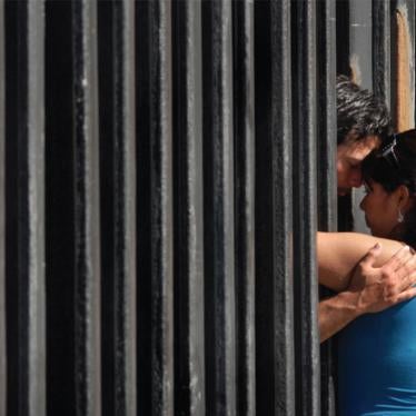 Mario Chavez, a US citizen, shares a moment with his wife, Lizeth Chvaez, a Mexican citizen, through the border fence at Playas de Tijuana.