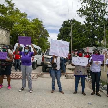 Des femmes brandissaient des pancartes appelant à la justice, devant le Palais de justice de Croix-des-Bouquets, à Haïti, le 14 mai 2020.