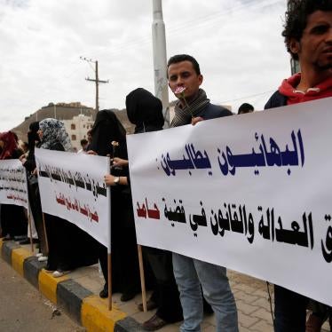 In this file photo, members of the Baha'i faith protest in Sanaa, Yemen, during a hearing in the case of a fellow Baha'i man suspected of contacts with Israel and charged with seeking to establish a base for the community in Yemen, April 3, 2016. Arabic writing on the poster reads, "Baha'is are demanding justice and law in the case of Hamed."