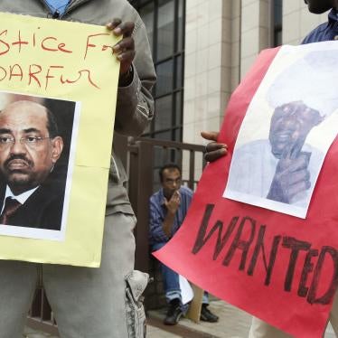 Protesters hold posters of Sudan's then-President Omar Hassan al-Bashir and Janjaweed leader Ali Kosheib (R) outside the European Union Council in Brussels, July 2008.