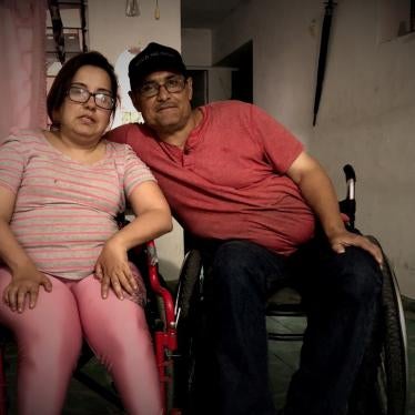 A man and woman in wheelchairs pose for a photo 