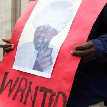 Un manifestant tenait une affiche montrant Ali Kosheib, un chef de milice soudanais recherché pour crimes de guerre commis au Darfour, devant le siège du Conseil de l'Union européenne à Bruxelles, en juillet 2008. Un autre manifestant (non visible sur cette photo) tenait une affiche montrant le président Omar el-Béchir, également accusé par la CPI de crimes de guerre.