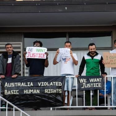 Asylum seekers and refugees hold placards during protest against their detention at Kangaroo Point Hotel in Brisbane, Australia, amid the Covid-19 crisis.