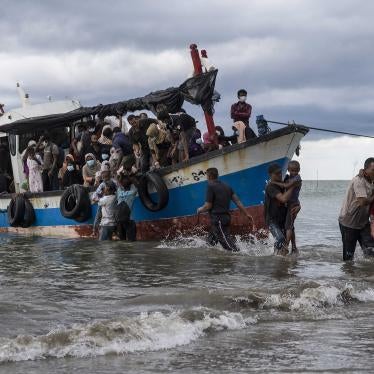 Local fishermen help Rohingya asylum seekers as they arrive in North Aceh, Indonesia, June 25, 2020.