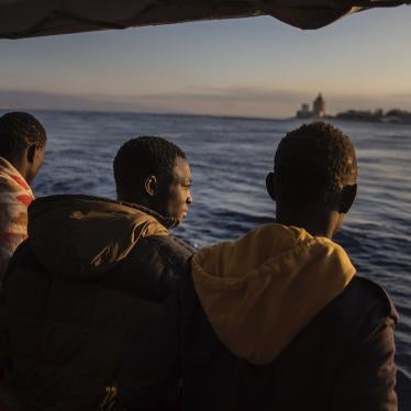 Men who were rescued off the Libyan coast in January, 2020 watch the city of Messina, Sicily from the deck of the Open Arms rescue vessel.