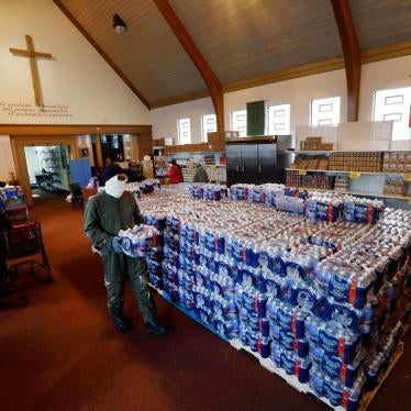 A man carries water for distribution at the Brightmoor Connection Food Pantry in Detroit, Michigan, March 23, 2020.