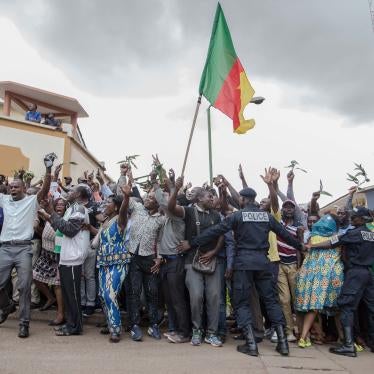 Hundreds of supporters raise their arms and wave the national flag while waiting to greet Cameroonian opposition leader Maurice Kamto in Yaoundé on October 5, 2019, the day of his release from prison.