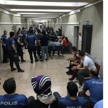 Defense lawyers, arrested in dawn raids on September 11 because they represent persons accused on terrorism charges, are handcuffed as they wait with police in the corridor of the Ankara courthouse, September 14, 2020 © 2020 private