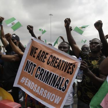 People hold banners and flags as they protest against police brutality in Lagos, Nigeria, Monday Oct. 19, 2020. 