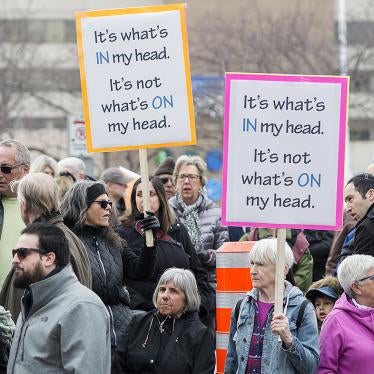 People in Montreal, Quebec, hold up signs during a demonstration on April 14, 2019 opposing Bill 21, a controversial provincial law passed that year banning certain categories of civil servants from wearing religious symbols at work. 