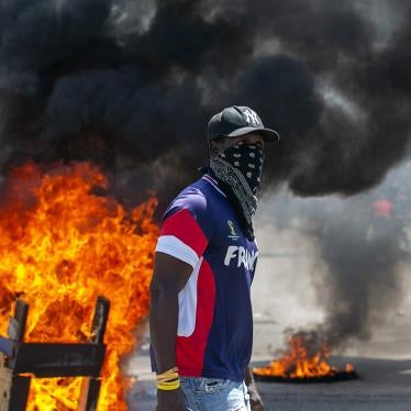 A protester walks past burning barricades during a protest demanding the resignation of President Jovenel Moïse in Port-au-Prince, Haiti, Saturday, Oct. 17, 2020.