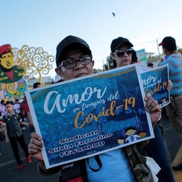 A woman holds a sign that reads "Love in Times of Covid-19" during a government-sponsored march in Managua, Nicaragua, on March 14, 2020.