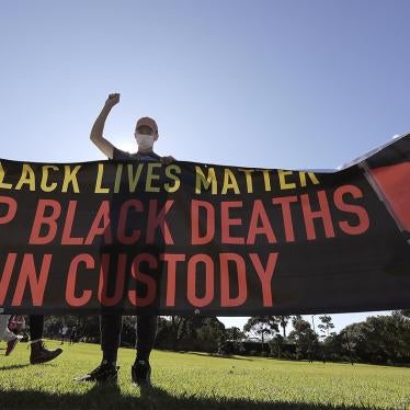 People hold a banner as thousands gather at a Black Lives Matter protest in Sydney.