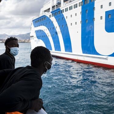 Two men on the Sea-Watch 4, a nongovernmental rescue ship, look on as they approach a ferry off the coast of Palermo, Sicily, Italy, on September 2, 2020, where rescued migrants undergo quarantine.