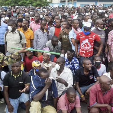 Kenyan police hold back passengers causing a crowd to form outside the ferry in Mombasa, Kenya, March 27, 2020.