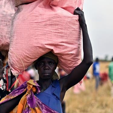 Villagers collect food aid from a World Food Programme (WFP) plane drop of grain and supplementary assistance at a village in Ayod county, South Sudan, on February 6, 2020.