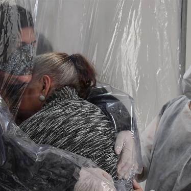 Uma mulher abraça sua mãe de 85 anos através de uma cortina de plástico transparente em um asilo para idosos em São Paulo, Brasil, em junho de 2020.