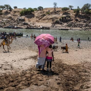 Refugees who fled the conflict in Ethiopia's Tigray region, which involved Eritrean as well as Ethiopian forces, arrive on the banks of the Tekeze River on the Sudan-Ethiopia border, November 20, 2020.