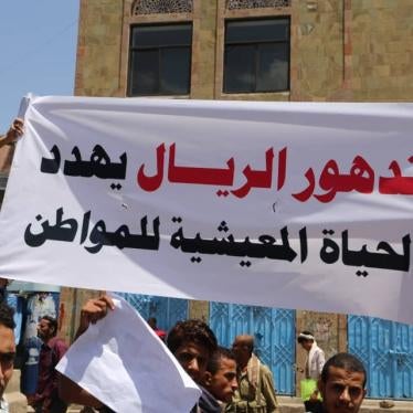 Demonstrators hold a banner that reads, "the depreciation of Yemen's rial currency threatens citizens' livelihood," in Taiz, Yemen, December 2018.