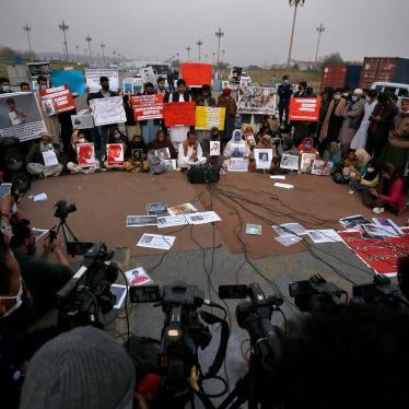 People hold placards and portraits of their missing family members during a press conference in Islamabad, Pakistan, February 20, 2021. 