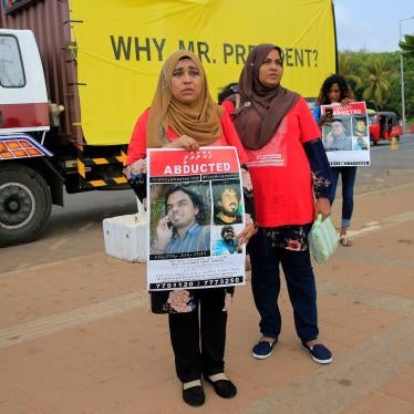 Relatives of disappeared Maldivian journalist Ahmed Rilwan Abdulla hold a silent protest during International Day of the Victims of Enforced Disappearances, holding signs.