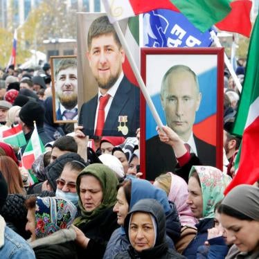 People hold portraits of Russian President Vladimir Putin and Chechen leader Ramzan Kadyrov during a rally marking National Unity Day in Grozny, southern Russia, Monday, Nov. 4, 2019.