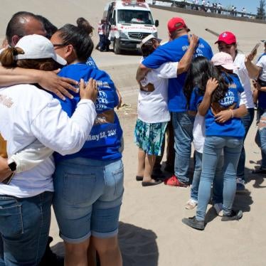 Immigrant families separated by immigration status, lack of visas, or deportations, are briefly reunited in the dry Rio Grande riverbed 