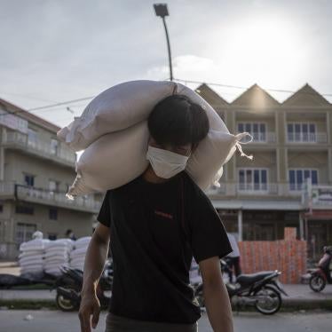 A resident of a Red Zone carries bags of rice donated to his house during the coronavirus pandemic.