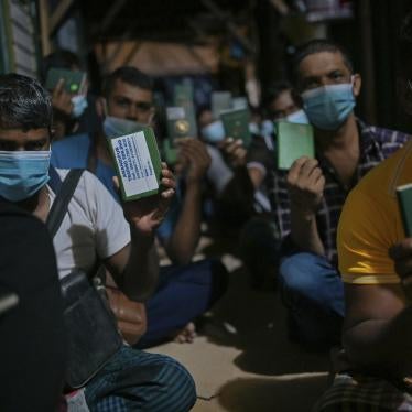 Migrant workers show their passport during a raid in Dengkil, outside Kuala Lumpur, Malaysia on June 21, 2021.
