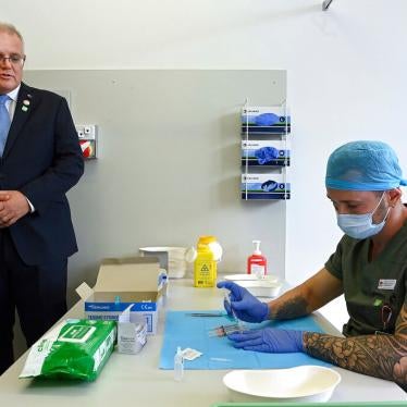 Australian Prime Minister Scott Morrison, left, watches a pharmacist prepare a simulated vaccine at the Sydney local health district vaccination hub in Sydney, February 19, 2021.