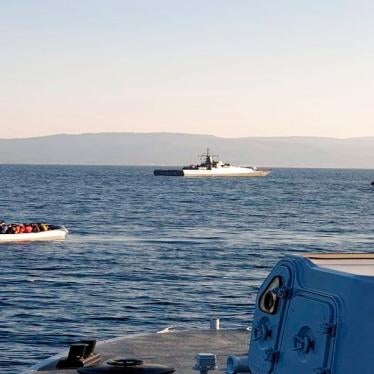 A dinghy with migrants, left, with Turkish ships in the background, in the narrow stretch of water between the eastern Greek island of Lesbos and the Turkish coast on April 2, 2021.
