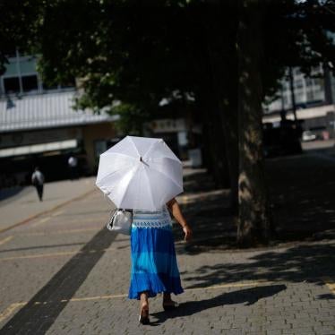 A woman walks under a parasol to shelter from the sun in Birmingham, U.K., on Tuesday, July 20, 2021. The U.K.'s Met Office has issued its first-ever Extreme Heat weather warning, stating that continuing high temperatures will lead to public health impacts.