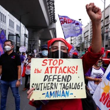 A woman carries a slogan condemning government attacks on activists at a rally to mark International Women's Day, Manila, Philippines on March 8, 2021.
