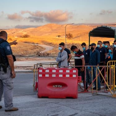 Palestinian laborers line up to cross a checkpoint at the entrance to the Israeli settlement of Maale Adumim, near Jerusalem, June 30, 2020. 