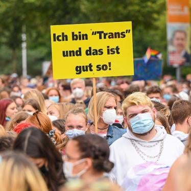 A demonstrator on a march in Oldenburg, Germany, on Christopher Street Day 2021, holds a sign with the inscription “I am ‘Trans’ and that's good!” September 21, 2021. © 2021 Mohssen Assanimoghaddam/picture-alliance/dpa/AP Images