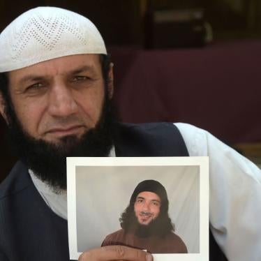 Afghan refugee Roman Khan at a refugee camp near Pakistan's northwestern city of Peshawar in September 2020, displays a photograph of his brother Asadullah Haroon, who is detained at the Guantanamo Bay detention center.