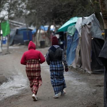 Migrant women walk inside a migrant encampment in Matamoros, Mexico, February 18, 2021.