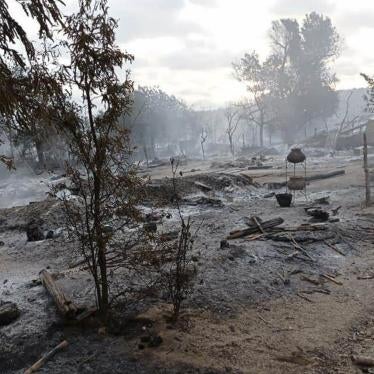 A person walks by a destroyed village