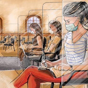 Women in face masks take notes while seated