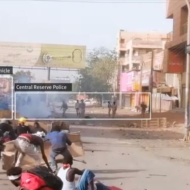 A screenshot from the video posted on Facebook. In the foreground protesters are using cardboard sheets as shields. In the background, a four-wheel armored vehicle is on the left with approximately 10 CRP officers in khaki camouflage standing nearby.