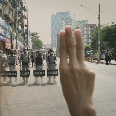 Myanmar Diaries screengrab of protester holding up three-finger salute in front of security forces