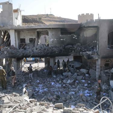 People inspect a damaged building in Sanaa, Yemen.