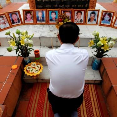 A former opposition party Cambodia National Rescue Party (CNRP) member prays in front of portraits of victims of the March 30, 1997 deadly grenade attack, during a Buddhist ceremony, in Phnom Penh, Cambodia, Friday, March 30, 2018.